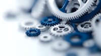Mechanical gears in white and blue colors arranged with selective focus creating depth effect, symbolizing technology, teamwork and industrial processes.