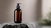 Amber glass pump bottle on rough stone surface against blurred background. Minimalist spa composition for cosmetic product presentation and skincare branding.