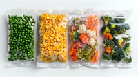 Frozen vegetables in transparent plastic bags arranged in row showing peas, corn, mixed vegetables and broccoli for healthy meal preparation and storage.