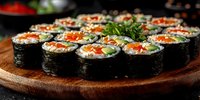 Fresh vegetable sushi rolls with salmon, avocado and red caviar garnished with green herbs served on wooden board. Traditional Japanese cuisine closeup.