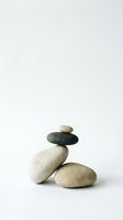 Balanced stack of smooth river stones in zen arrangement on white background for meditation and wellness concepts.