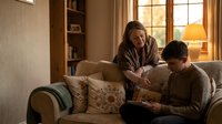 Mature Caucasian woman comforting upset teenage son on living room sofa during golden hour creating warm intimate family moment for counseling concepts.