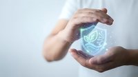 Hands protecting glowing shield with leaf icon, representing eco-friendly security, environmental protection, and sustainable business practices for corporate and technology concepts.