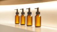 Amber glass pump bottles arranged in row on white surface with soft natural lighting and shadows, minimalist composition for cosmetic and wellness products.