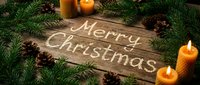 Merry Christmas text on rustic wooden background surrounded by fir branches, pine cones, and glowing candles, festive holiday greeting card.