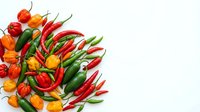 Fresh red, orange, and green chili peppers arranged on white background, isolated for culinary, cooking, and food design projects.