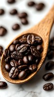 Fresh roasted coffee beans in wooden spoon on marble background, macro shot with selective focus showing rich texture and natural brown tones.