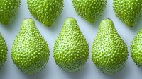 Fresh green breadfruit arranged in rows on light background, showing detailed textured skin pattern. Exotic tropical produce photography for food and agriculture concepts.