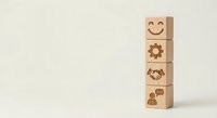 Wooden blocks with business icons stacked vertically showing customer service symbols including smiley face, gear, handshake and support on neutral background.