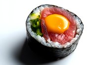 Fresh sushi roll with raw tuna, quail egg yolk, green onion and rice wrapped in nori seaweed on white background, macro food photography.