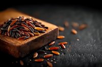 Raw black and red rice grains scattered from wooden scoop on dark textured background with dramatic lighting and shallow depth of field for food photography.