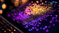 Vibrant digital data visualization with glowing orange and purple bokeh lights reflecting off screen surface, showing abstract technology pattern of information flow.