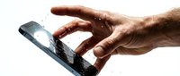 Damaged smartphone with cracked screen held by male hand under water splash, showing device malfunction and water damage risk for repair and insurance concepts.