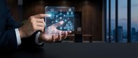 Businessman holding futuristic holographic interface with digital icons and data visualization in modern office environment for technology presentations.