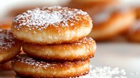 Stack of golden fried donuts dusted with powdered sugar on white surface, freshly baked pastry dessert for bakery menu and food photography.