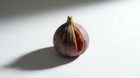 Fresh ripe fig fruit cut in half showing red flesh and seeds on white background with shadow for healthy eating and Mediterranean cuisine concepts.