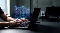 Professional man analyzing financial data on laptop with glowing digital dashboard interface displaying charts and analytics in modern office workspace.