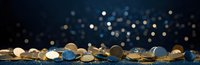 Golden coins scattered on dark reflective surface with blurred bokeh lights in background creating luxurious financial atmosphere. Perfect for business and wealth concepts.