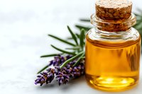 Essential lavender oil in glass bottle with fresh purple lavender flowers and rosemary herbs on white background. Natural aromatherapy concept.