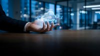 Businessman holding glowing cloud computing hologram above desk, symbolizing digital transformation, data storage, and modern network technology in office.