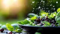 Fresh spinach salad with dried cranberries in bowl with water droplets and sunlight creating healthy organic meal for nutrition and wellness lifestyle.