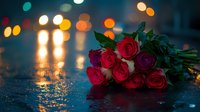 Romantic bouquet of red and pink roses lying on wet asphalt with colorful bokeh lights in rainy evening atmosphere.