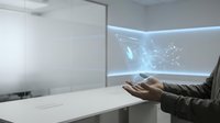 Professional presenting holographic data visualization and network connections in modern conference room for business technology presentations.