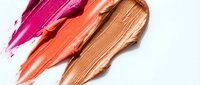 Colorful lipstick smears in pink, coral, and nude shades on white background, showcasing vibrant makeup textures for beauty and cosmetic concepts.