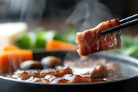 Juicy grilled pork belly slice held with chopsticks over hot pan with steam rising, selective focus on meat with blurred vegetables in background.