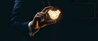 Businessman in dark suit holding glowing light bulb against black background, symbolizing innovation, creativity, and business ideas for corporate success.