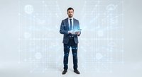 Professional businessman in dark suit standing confidently with digital technology icons and network connections overlay on white background.