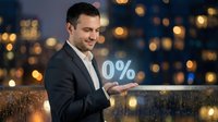 Businessman in dark suit holding zero percent symbol on glowing tablet against blurred city lights at night, representing interest rates, financial offers, or promotional deals.