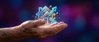 Senior hand holding glowing house model with percentage symbol representing mortgage rates, real estate investment, property loans on dark background.
