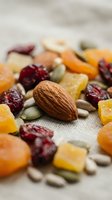 Mixed nuts, dried fruits and seeds scattered on linen fabric. Healthy snack mix with almonds, cranberries, apricots and pumpkin seeds for organic nutrition.