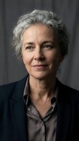 Professional mature woman with gray hair in business attire smiling confidently at camera for corporate headshot and executive portrait photography.