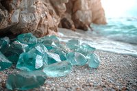 Raw aquamarine crystals scattered on sandy beach near rocky cliff at sunset, natural mineral formations glowing in warm light against turquoise ocean waves.
