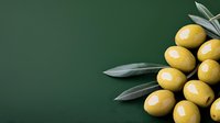 Fresh green olives with leaves on dark green background, macro food photography with copy space for menu design and restaurant promotion.