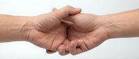 Two hands joining together in a fist bump gesture, showing unity, agreement, and teamwork between colleagues or friends on white background.
