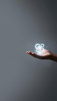 Hand of a male professional holding glowing shield and gear icons with digital particles, representing cybersecurity, data protection, and technology solutions for business.