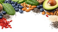 Superfood ingredients with blueberries, avocado, nuts, seeds and goji berries arranged on white background for healthy nutrition and wellness lifestyle.