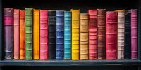 Row of vintage multicolored books with worn fabric spines arranged on dark wooden shelf, creating rainbow spectrum display of classic literature collection.