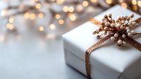 White gift box decorated with golden ribbon and white berries against blurred festive bokeh lights background, creating magical holiday atmosphere.
