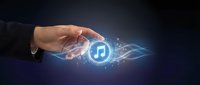 Hand holding glowing music note symbol with digital light effects and data streams, representing audio technology, streaming services, and digital music innovation.