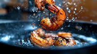 Grilled shrimp with spices and seasonings splashing in oil against dark background, dramatic lighting captures water droplets in motion for food photography.