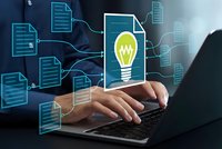 Business professional typing on laptop with digital innovation concept featuring glowing lightbulb and connected document network for creative solutions.