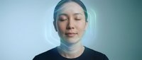Asian woman with closed eyes wearing futuristic transparent helmet or face shield against blue gradient background for technology and innovation concepts.