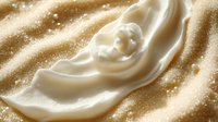 Creamy white cosmetic product swirled on golden glitter background, suitable for beauty, skincare, and makeup advertising campaigns.