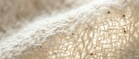 Natural burlap fabric texture with loose weave pattern showing organic fiber details and neutral beige tones for rustic design projects.