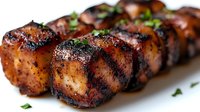 Grilled sausages with herbs on white background. Barbecue meat products with crispy golden brown crust and fresh parsley garnish for cooking and food design.