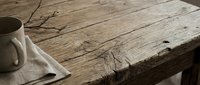 Rustic wooden table with white ceramic mug and dried branches, creating a minimalist, natural aesthetic for home decor and lifestyle content.